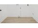 A simple laundry room area with white walls and light-colored wood floors ready for a washer and dryer hookup at 2017 Rebecca Dr, Clearwater, FL 33764