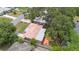 Features include a red tile roof, covered patio with chairs, fenced yard, and mature trees at 2333 Indigo Dr, Clearwater, FL 33763