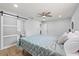 Cozy bedroom with a ceiling fan, hardwood floors, and a modern sliding barn door to the en suite bathroom at 2333 Indigo Dr, Clearwater, FL 33763