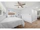 Bright bedroom featuring a ceiling fan, wood-look floors, and an ensuite bathroom at 2333 Indigo Dr, Clearwater, FL 33763