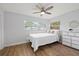 Cozy bedroom with a ceiling fan, wood-look floors, natural light, and a chest of drawers at 2333 Indigo Dr, Clearwater, FL 33763