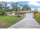 Features include a one-car garage, new driveway, mature trees and landscaping, and a walkway at 2333 Indigo Dr, Clearwater, FL 33763