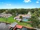Aerial view of a home with a pool, boat dock, lush landscaping, and waterfront access at 2401 Roberta Ln, Clearwater, FL 33764