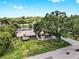 Aerial view of a home with a huge yard, screened-in lanai, mature trees, and beautiful landscaping at 2401 Roberta Ln, Clearwater, FL 33764
