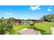 Manicured backyard with mature landscaping, barbecue, waterfront views, and a private dock at 2401 Roberta Ln, Clearwater, FL 33764