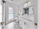 Well-lit bathroom featuring a stylish mirror, sleek vanity, and decorative tile flooring at 2401 Roberta Ln, Clearwater, FL 33764