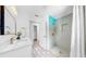 Bright bathroom features a modern shower, unique flooring, and updated vanity with designer fixtures at 2401 Roberta Ln, Clearwater, FL 33764