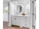 Modern bathroom with custom vanity, stylish round mirror, and contemporary design elements at 2401 Roberta Ln, Clearwater, FL 33764