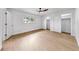 Bright, empty bedroom features white walls, wood floors, ceiling fan, and closet at 2401 Roberta Ln, Clearwater, FL 33764