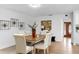 Dining room with modern wood table, white upholstered chairs, and contemporary decor at 2401 Roberta Ln, Clearwater, FL 33764