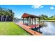A private wooden dock with covered seating area offering direct access to a picturesque canal, perfect for boating at 2401 Roberta Ln, Clearwater, FL 33764