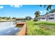 Canal-front home with a private dock, lush landscaping, and screened patio area for outdoor living and entertaining at 2401 Roberta Ln, Clearwater, FL 33764