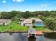 Waterfront property features a private boat dock, lush landscaping, and a refreshing screened-in pool at 2401 Roberta Ln, Clearwater, FL 33764