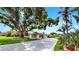 Charming single-story home with well-manicured landscaping, a long driveway, and mature trees in a serene setting at 2401 Roberta Ln, Clearwater, FL 33764