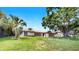 Single-story home with a large front yard and mature shade trees creating a peaceful and inviting curb appeal at 2401 Roberta Ln, Clearwater, FL 33764