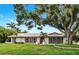 Inviting one-story home with red tile roof, shutters, and lush landscaping at 2401 Roberta Ln, Clearwater, FL 33764