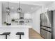 Bright kitchen featuring white cabinetry, stainless steel appliances, a center island, and modern pendant lighting at 2401 Roberta Ln, Clearwater, FL 33764