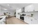 Modern kitchen with white cabinets, stainless steel appliances, quartz countertops, and stylish backsplash at 2401 Roberta Ln, Clearwater, FL 33764