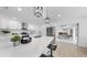 Modern white kitchen featuring a center island with seating, stainless steel appliances, and an open floor plan at 2401 Roberta Ln, Clearwater, FL 33764