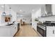 Well-lit kitchen with white cabinets, stainless steel appliances, and an open view into the dining room at 2401 Roberta Ln, Clearwater, FL 33764