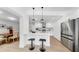 The white kitchen has an island with barstools, stainless appliances, and is open to the dining area at 2401 Roberta Ln, Clearwater, FL 33764