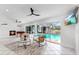 Spacious living room with fireplace, piano, and tile floor, opening to an outdoor pool at 2401 Roberta Ln, Clearwater, FL 33764