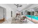 Bright living room with modern ceiling fans, a cozy fireplace, and glass sliders to the pool at 2401 Roberta Ln, Clearwater, FL 33764