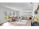 The bright living room offers neutral décor, wood floors, and three large windows for natural light at 2401 Roberta Ln, Clearwater, FL 33764