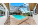 Enclosed pool with brick pavers, clear blue water, screened enclosure and canal views at 2401 Roberta Ln, Clearwater, FL 33764