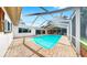 Enclosed pool with clear blue water, brick pavers, screened enclosure and outdoor seating at 2401 Roberta Ln, Clearwater, FL 33764