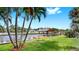 Dock on canal provides access to waterfront living, accented by palm trees and bright blue skies at 2401 Roberta Ln, Clearwater, FL 33764