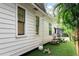 White siding of the home with a backyard setup with astroturf, patio furniture, and a small shed at 2412 W Prospect Rd, Tampa, FL 33629