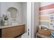 Modern bathroom with a sleek vanity, round mirror, and stylish fixtures in a neutral palette at 2412 W Prospect Rd, Tampa, FL 33629