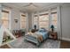 Cozy bedroom features a ceiling fan, multiple windows with blinds, and a comfortable bed at 2412 W Prospect Rd, Tampa, FL 33629