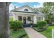 A charming home with manicured bushes and green lawn leads to a welcoming porch, all under a bright sky at 2412 W Prospect Rd, Tampa, FL 33629