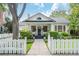 Charming two-story home featuring a classic white picket fence, lush landscaping, and a welcoming front porch at 2412 W Prospect Rd, Tampa, FL 33629