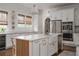 Bright kitchen featuring white cabinetry, large island with sink, stainless steel appliances, and wood flooring at 2412 W Prospect Rd, Tampa, FL 33629