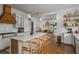 Open concept kitchen with seating at the island, stainless appliances, white countertops, and abundant natural light at 2412 W Prospect Rd, Tampa, FL 33629