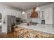 Well-lit kitchen with white cabinets, a stainless-steel refrigerator, and a spacious island with barstool seating at 2412 W Prospect Rd, Tampa, FL 33629