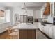 Modern kitchen with white cabinets, stainless steel appliances, large center island with seating, and wood-look flooring at 2412 W Prospect Rd, Tampa, FL 33629