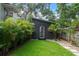 A black shed in the backyard with a well-kept lawn and clean landscaping for a peaceful environment at 2412 W Prospect Rd, Tampa, FL 33629