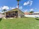 Large backyard with a screened lanai, outdoor seating, and well-maintained lawn, ideal for outdoor living at 24811 Gun Smoke Dr, Land O Lakes, FL 34639