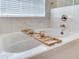 Relaxing bathtub features marble surround and a wood caddy, a perfect spot for unwinding at 24811 Gun Smoke Dr, Land O Lakes, FL 34639