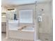 Elegant bathroom featuring a soaking tub, a glass-enclosed shower, and modern fixtures at 24811 Gun Smoke Dr, Land O Lakes, FL 34639
