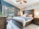 Cozy bedroom with a wood accent wall, a ceiling fan, and sliding glass doors to the backyard at 24811 Gun Smoke Dr, Land O Lakes, FL 34639