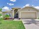 Charming single-Gathering home with manicured lawn, mature landscaping, and an attached two car garage at 24811 Gun Smoke Dr, Land O Lakes, FL 34639