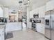 Open-concept kitchen with stainless steel appliances, and an island that flows into the living area at 24811 Gun Smoke Dr, Land O Lakes, FL 34639