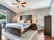 Cozy main bedroom features shiplap wall, a large bed, and access to a private outdoor patio at 24811 Gun Smoke Dr, Land O Lakes, FL 34639