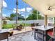Screened patio with dining table and view of fenced backyard with fire pit at 24811 Gun Smoke Dr, Land O Lakes, FL 34639