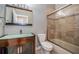 Bathroom with wood-look vanity, glass vessel sink, tiled shower, and glass shower door at 2691 Saddlewood Ln, Palm Harbor, FL 34685